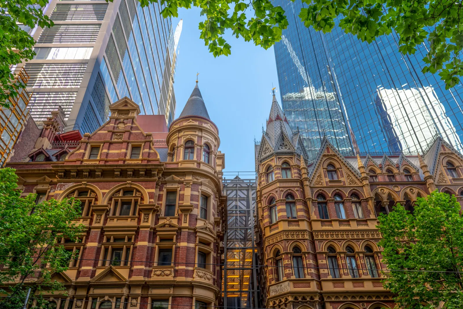 Victorian sandstone and brick buildings on Collins Street, Melbourne, with glass towers behind them
