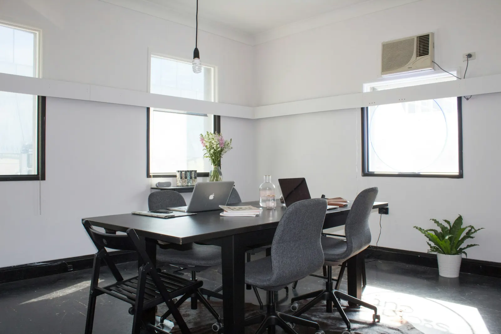 A bright meeting room with a long table, a laptop and six chairs in Fortitude Valley, Brisbane